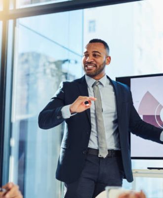 Shot of a young businessman delivering a presentation to his colleagues in the boardroom of a modern office